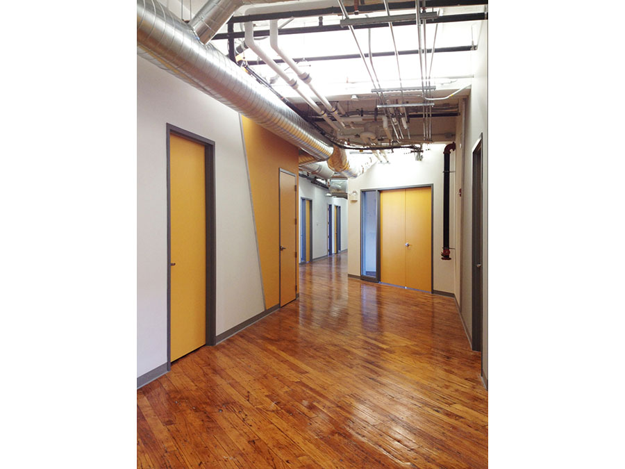 Bright, wide hallway with warm wood floor.