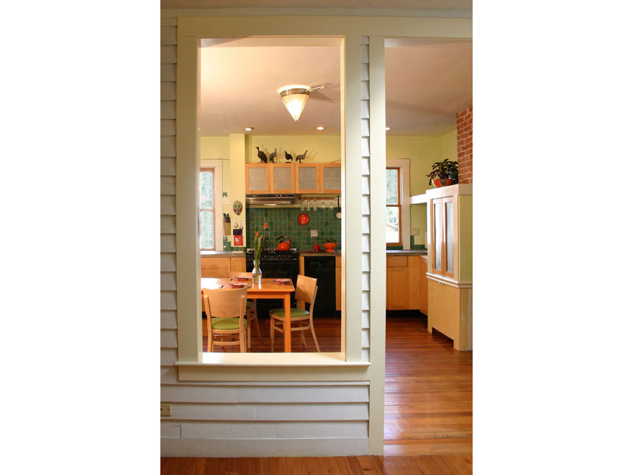 Historic home renovation creates a view into kitchen from hall in the Cambridgeport house.