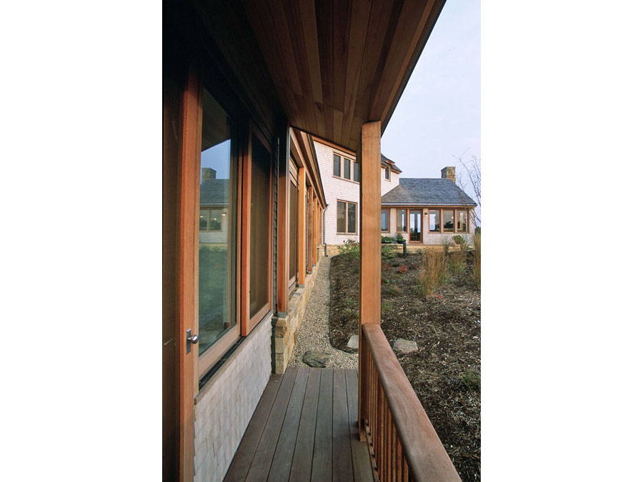 Green home design provides a sheltered porch at the Cape Cod house.