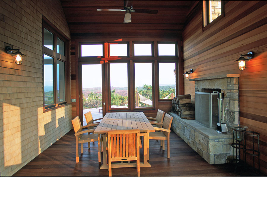 Green home design creates a sheltered outdoor living area in the Cape Cod house.